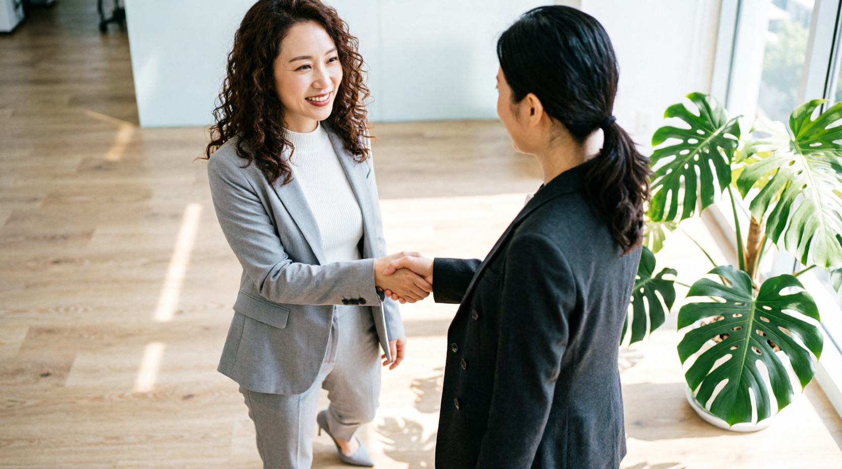Two partners shaking hands in a modern office